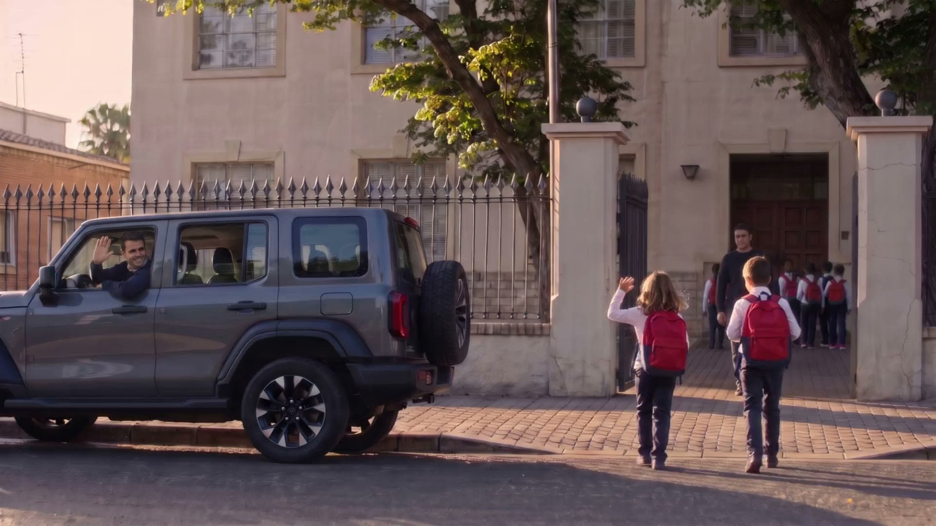 Papá deja a los chicos en el colegio y los saluda desde la camioneta eléctrica